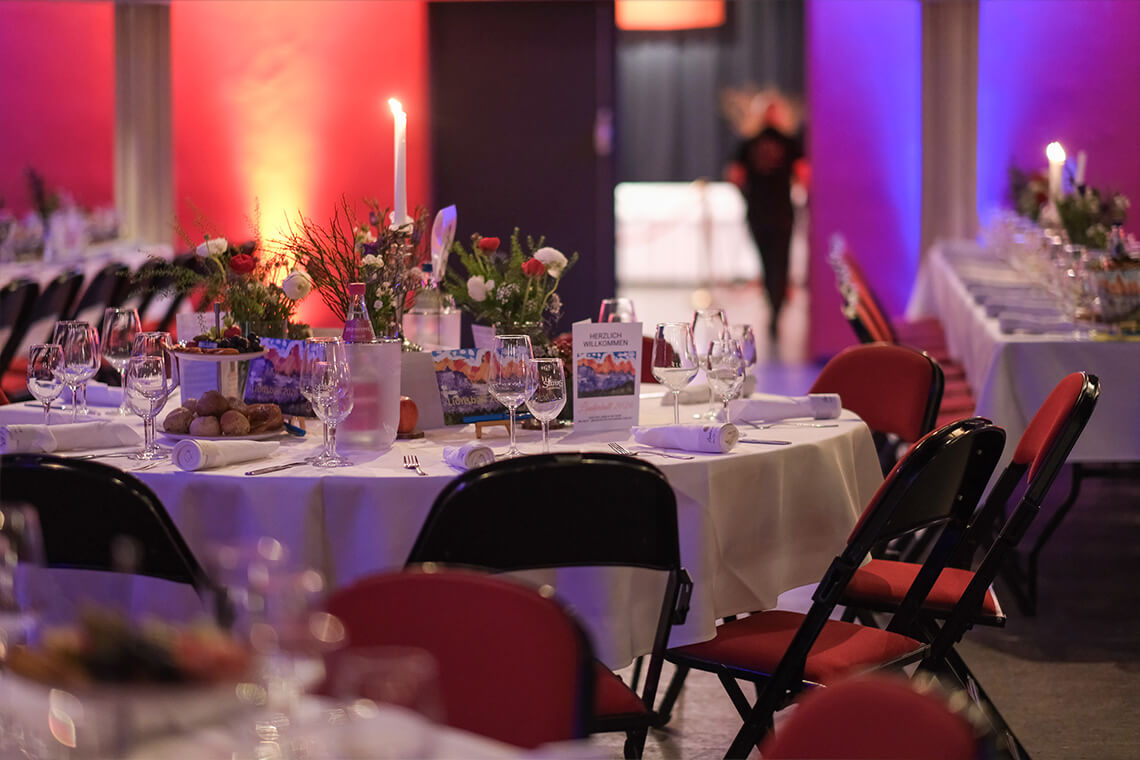 Länderball 2026 - Detailansicht eines festlich gedeckten Tisches mit Blumen, Kerze und Menükarte